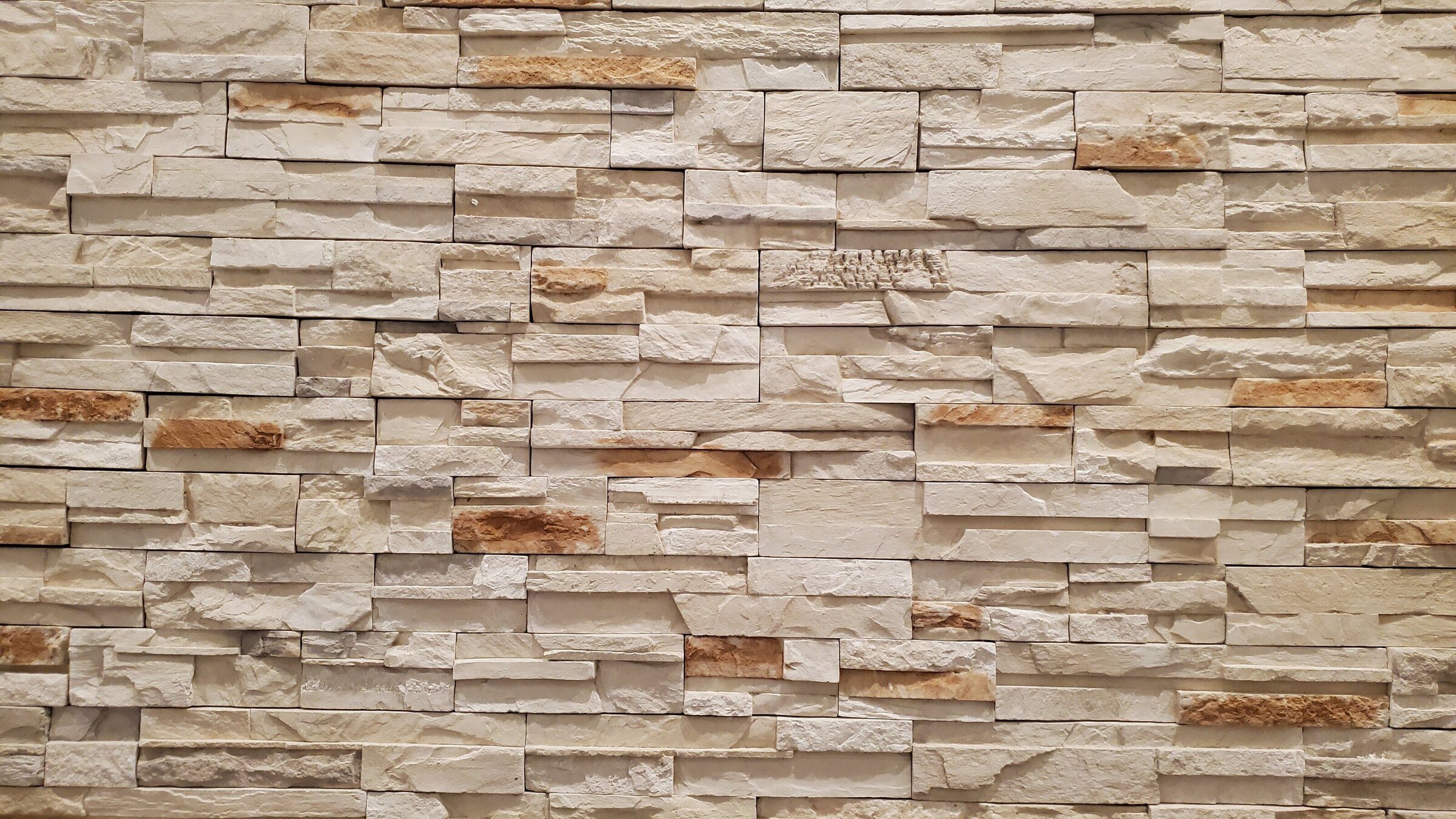 Beige stone brick wall with varied textures.