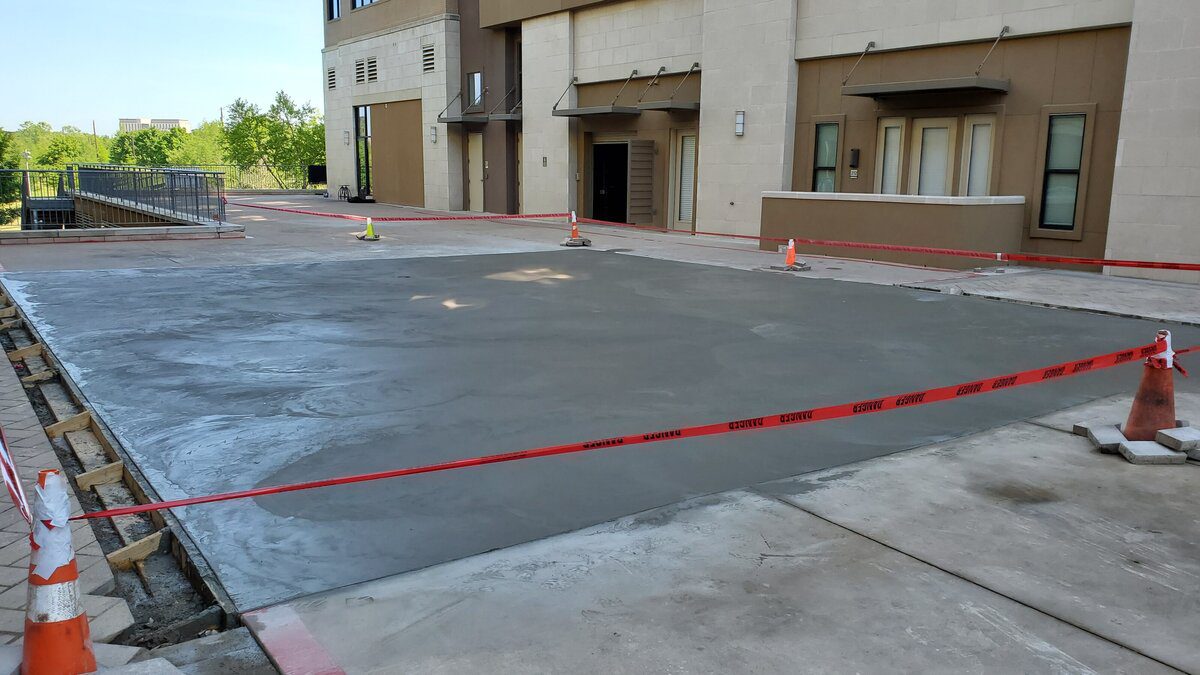 Freshly poured concrete area with caution tape.