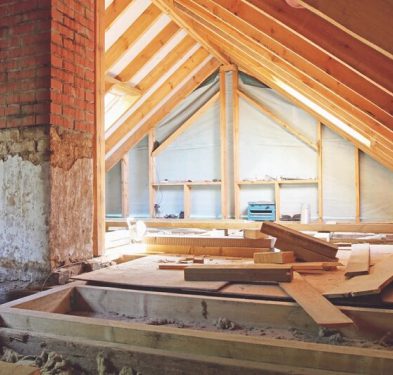 Attic under renovation with wooden beams.