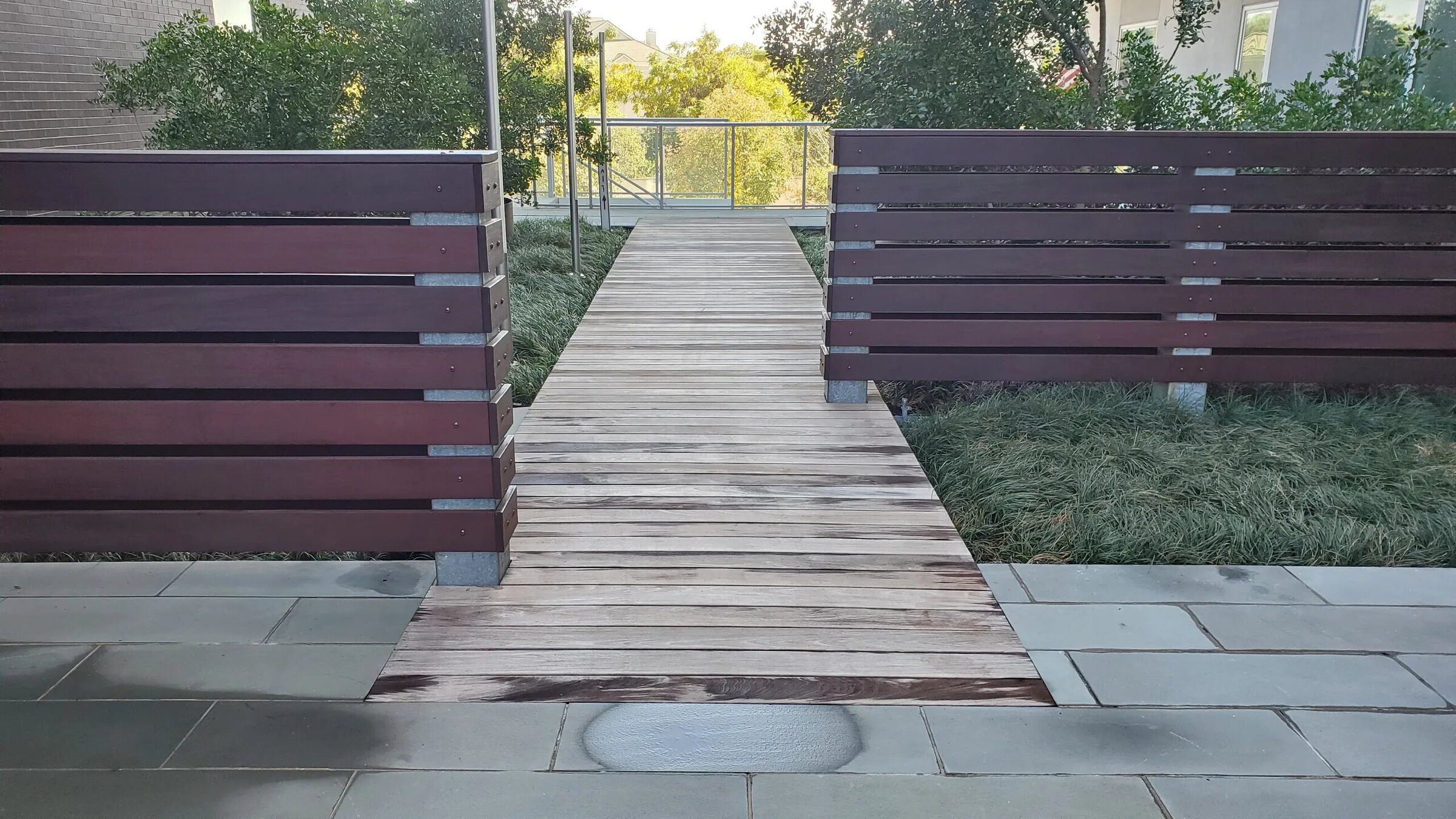 Wooden pathway between two brown fences.