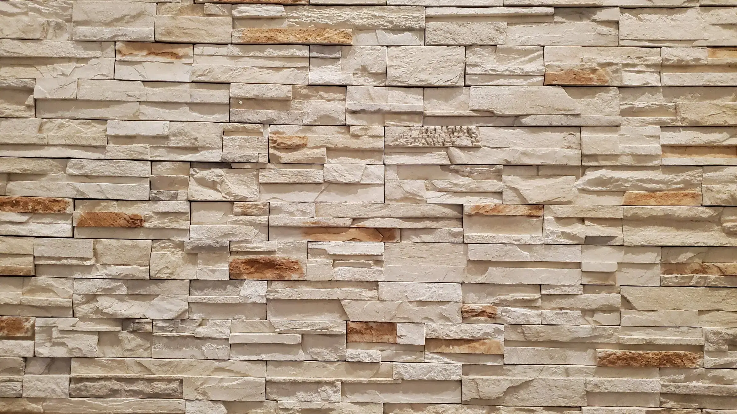 Beige stone brick wall with varied textures.